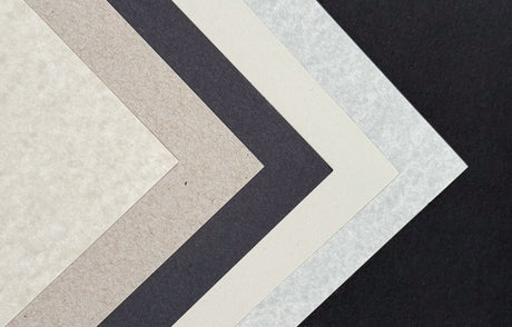 A stack of gray-colored paper sheets in various shades, displaying different textures and weights.