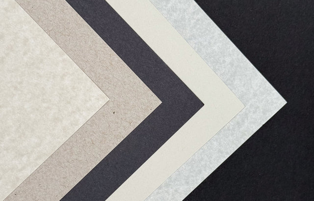 A stack of gray-colored paper sheets in various shades, displaying different textures and weights.