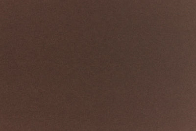 A deep and dark brown-black paper viewed in close detail. 
